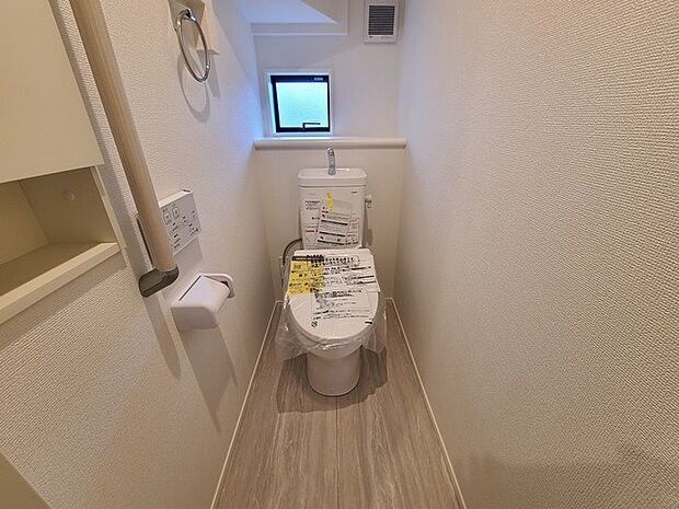 ウォシュレット機能付きのトイレ。換気のしやすい窓付きで、収納もあり実用性も兼ね備えた造り。