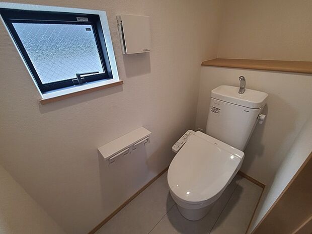 ウォシュレット機能付きのトイレ。換気のしやすい窓付きで、収納もあり実用性も兼ね備えた造り。 