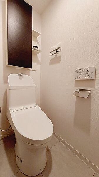 ウォシュレット機能付きのトイレ。収納もあり実用性も兼ね備えた造り。