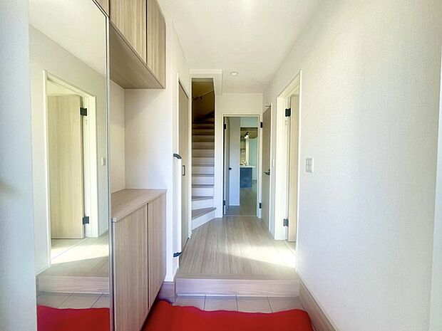 お宅の顔となる明るく開放的な玄関。ご家族皆様様の靴を収納できるスペースと全身鏡があり、お出掛け前に身だしなみチェックもできます。 