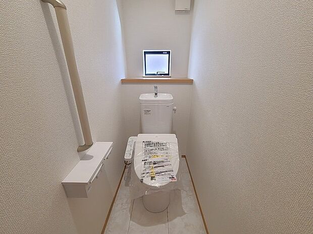 ウォシュレット機能付きのトイレ。換気のしやすい窓付きで、収納もあり実用性も兼ね備えた造り。