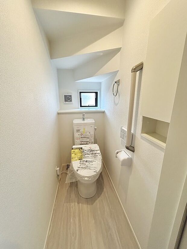 ウォシュレット機能付きのトイレ。収納もあり実用性も兼ね備えた造り。