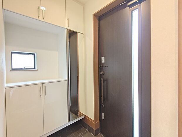 大きな靴棚を配した玄関ホール。靴棚に設置した姿見鏡はお出かけ前の身だしなみチェックにお役立てください！