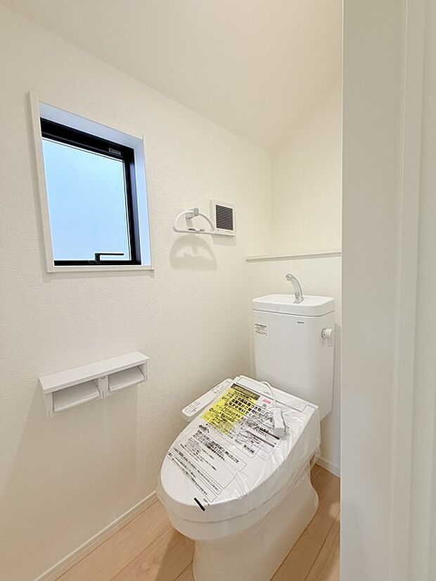ウォシュレット機能付きのトイレ。換気のしやすい窓付きで、収納もあり実用性も兼ね備えた造り。