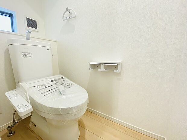 ウォシュレット機能付きのトイレ。換気のしやすい窓付きで、収納もあり実用性も兼ね備えた造り。