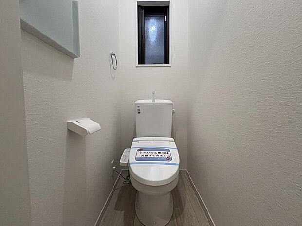 ウォシュレット機能付きのトイレ。換気のしやすい窓付きで、収納もあり実用性も兼ね備えた造り。