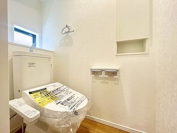 ウォシュレット機能付きのトイレ。換気のしやすい窓付きで、収納もあり実用性も兼ね備えた造り。