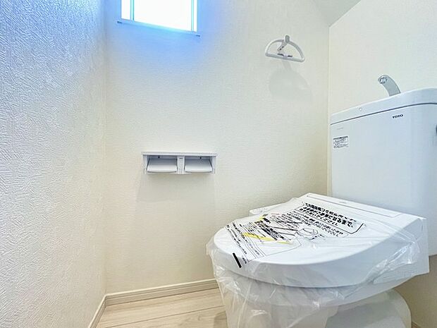 ウォシュレット機能付きのトイレ。換気のしやすい窓付きで、収納もあり実用性も兼ね備えた造り。