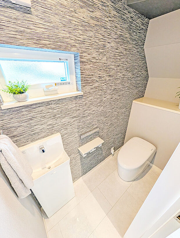 ウォシュレット機能付きのトイレ。換気のしやすい窓付きで、収納もあり実用性も兼ね備えた造り。