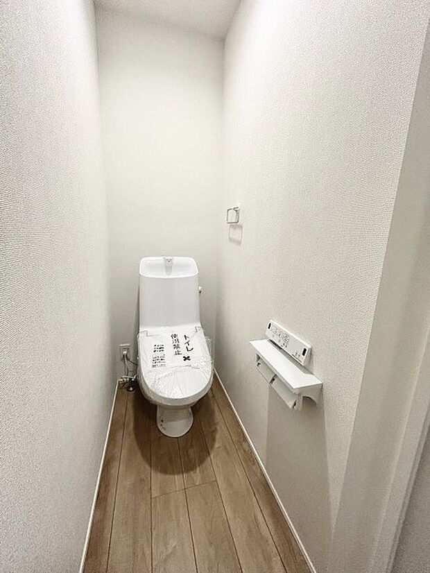 ウォシュレット機能付きのトイレ。収納もあり実用性も兼ね備えた造り。