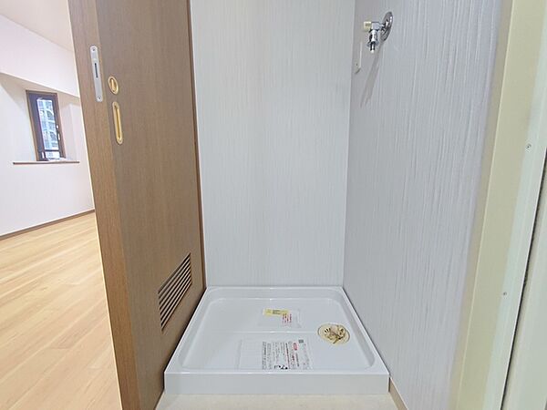 新品の防水パンが置かれた洗濯機置き場。 防水パンは水漏れを防ぐだけでなく、洗濯機運転中の振動・騒音を抑えてくれます。