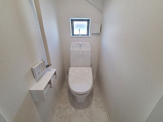 ウォシュレット機能付きのトイレ。換気のしやすい窓付きで、収納もあり実用性も兼ね備えた造り。