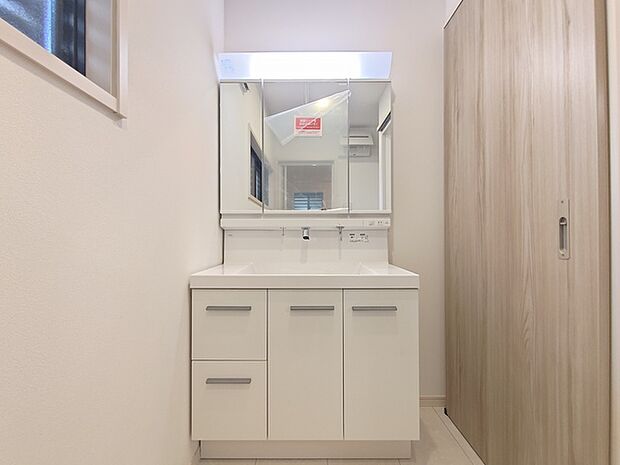 収納付きの洗面化粧台。 引き出し収納がある他、鏡の裏側も収納棚になっています。