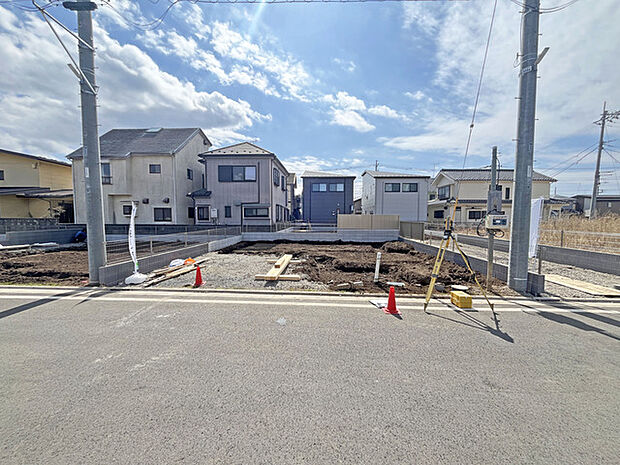 青空と白い雲が広がる広々とした空の下、新しい住まいが生まれようとしている穏やかな場所