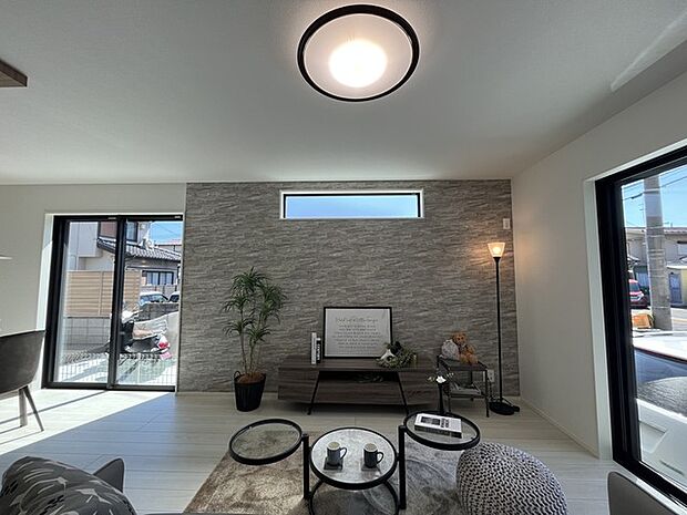 石材調の壁が落ち着きのある空間に趣を添え、広々とした窓から自然な光が優しく室内に広がります。洗練されたデザインと心地よい温かみが、穏やかな時間を演出します