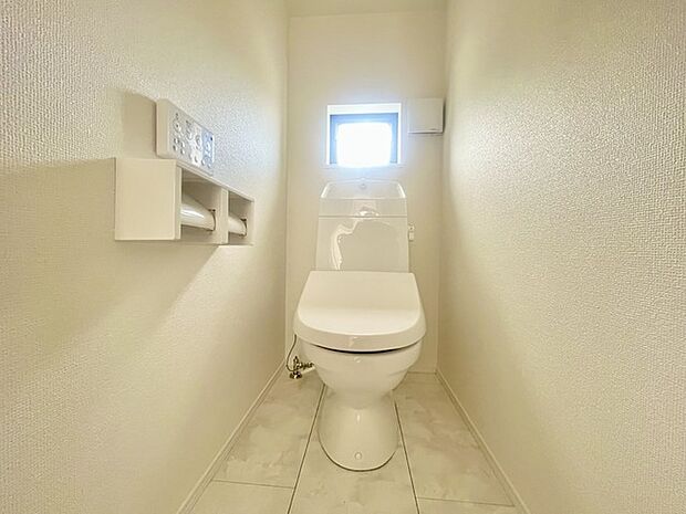 ウォシュレット機能付きのトイレ。換気のしやすい窓付きで、収納もあり実用性も兼ね備えた造り。