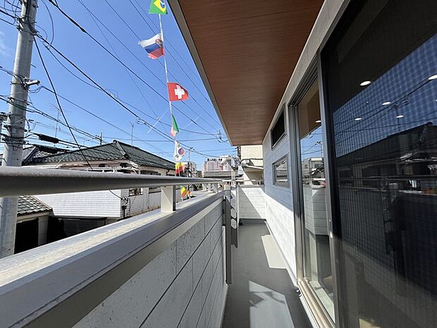 青い空を背景に、世界各国の国旗が風に揺れる心地よい風景。日常に彩りを添える、開放感あふれる空間が広がります