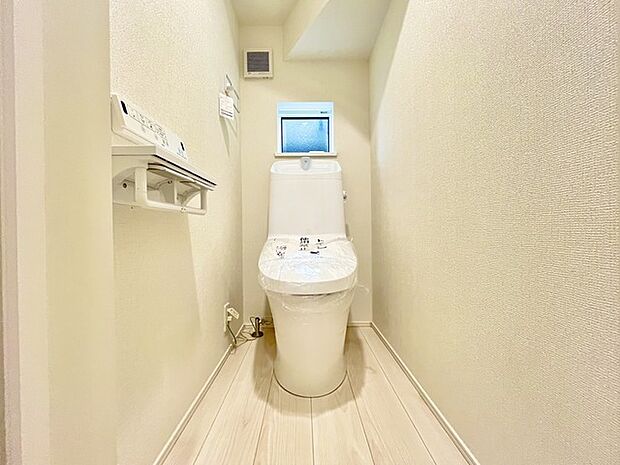 ウォシュレット機能付きのトイレ。換気のしやすい窓付きで、収納もあり実用性も兼ね備えた造り。