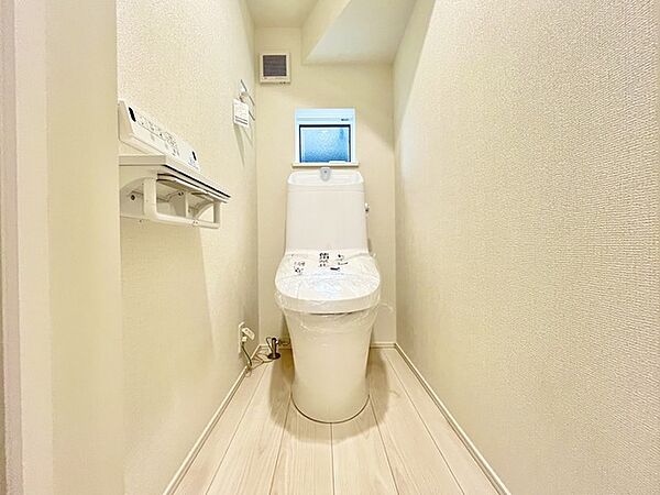 ウォシュレット機能付きのトイレ。換気のしやすい窓付きで、収納もあり実用性も兼ね備えた造り。