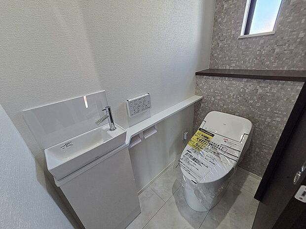 ウォシュレット機能付きのトイレ。換気のしやすい窓付きで、収納もあり実用性も兼ね備えた造り。