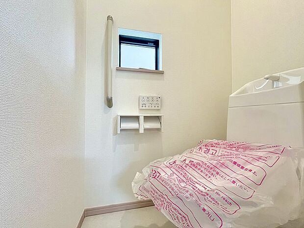 ウォシュレット機能付きのトイレ。換気のしやすい窓付きで、収納もあり実用性も兼ね備えた造り。