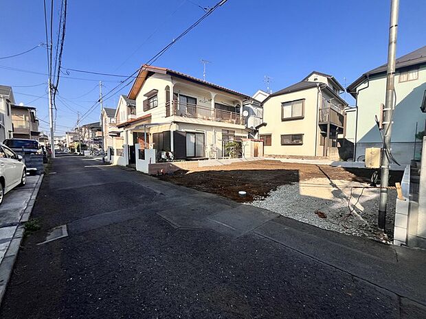 澄み渡る青空の下、穏やかな時間が流れる住宅街。建物の個性と整然とした街並みが調和し、心地よい暮らしを予感させます (5m)