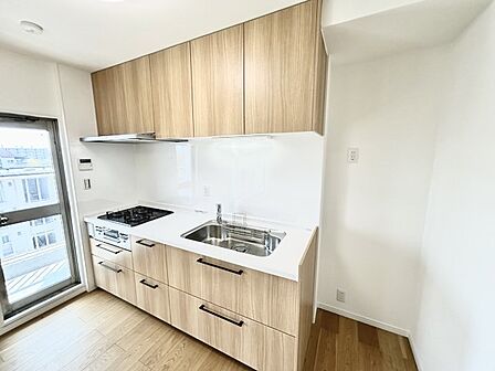 壁付のキッチンは上部に収納が作りやすいのがメリット。空間を有効活用したすっきりとしたデザイン。