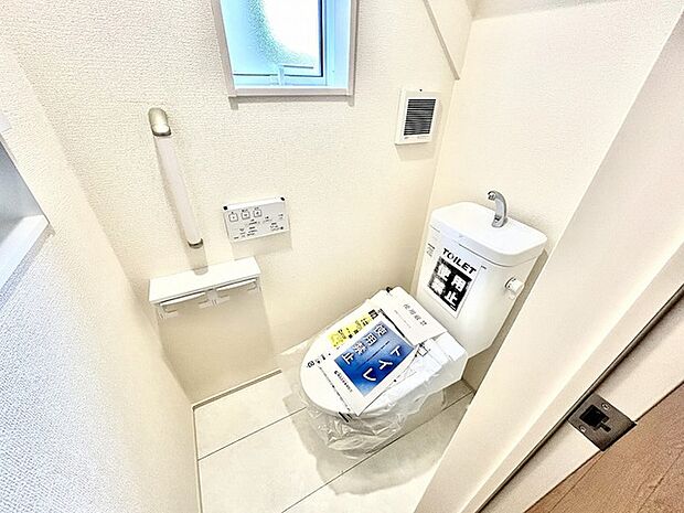 ウォシュレット機能付きのトイレ。換気のしやすい窓付きで、収納もあり実用性も兼ね備えた造り。