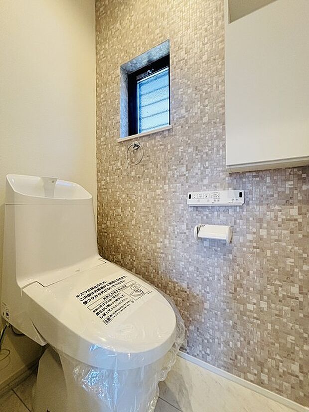 ウォシュレット機能付きのトイレ。換気のしやすい窓付きで、収納もあり実用性も兼ね備えた造り。