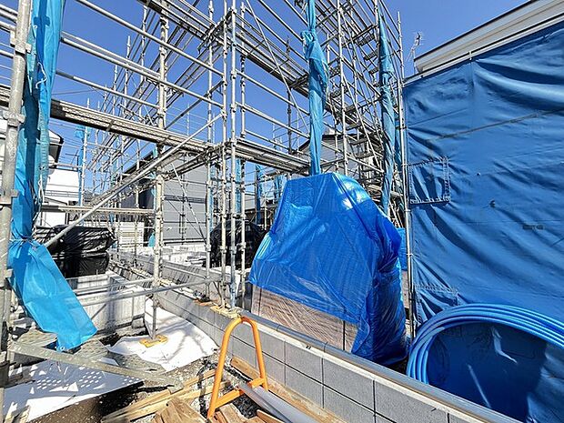 青いシートが広がり、賑わいを見せる建設現場。未来への期待を胸に、心地よい空間が形作られていく様子は、これから始まる新しい暮らしへの希望を掻き立てます