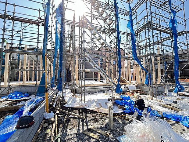 青いシートが風になびき、力強い構造体が空を支える、都市の鼓動を感じさせる光景