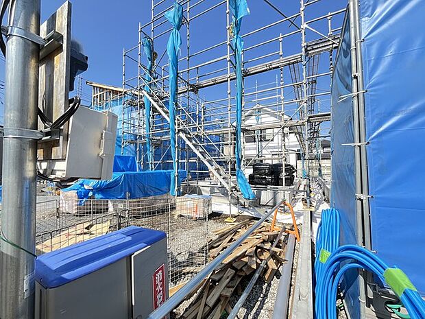 青いシートに囲まれ、活気あふれる建設現場。未来への期待を抱きながら、新たな暮らしの舞台が創り上げられていく様が感じられます