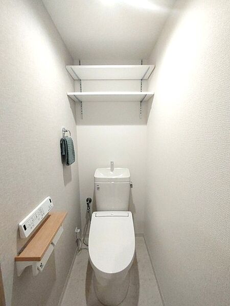 ウォシュレット機能付きのトイレ。収納もあり実用性も兼ね備えた造り。