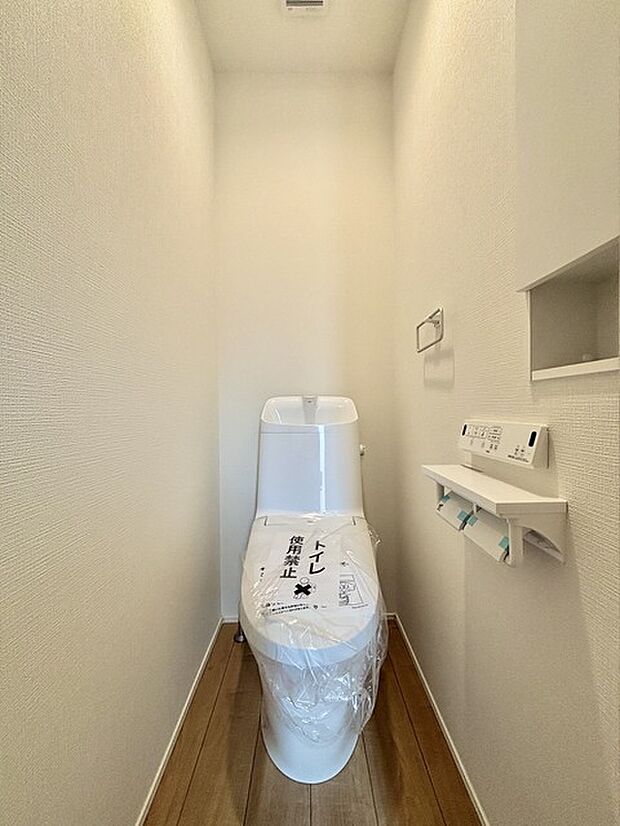 ウォシュレット機能付きのトイレ。収納もあり実用性も兼ね備えた造り。 
