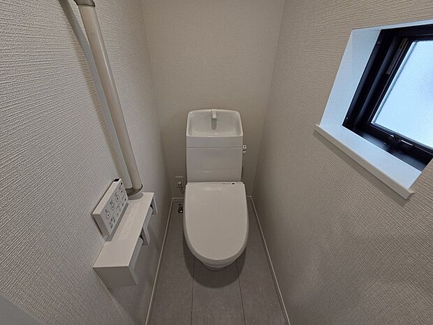 ウォシュレット機能付きのトイレ。換気のしやすい窓付きで、収納もあり実用性も兼ね備えた造り。 