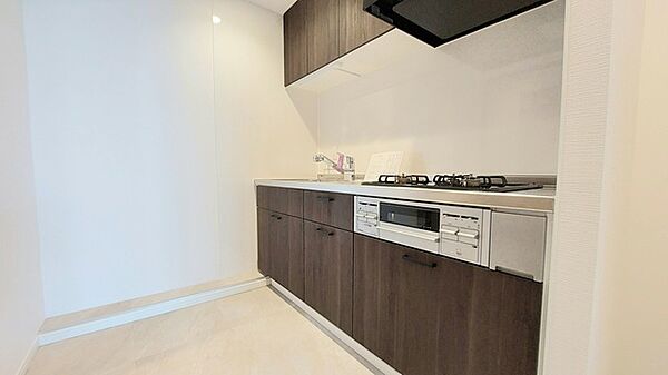 壁付のキッチンは上部に収納が作りやすいのがメリット。空間を有効活用したすっきりとしたデザイン。