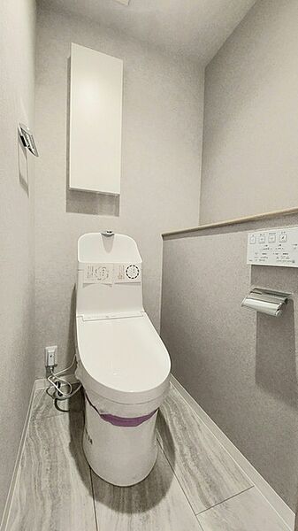 ウォシュレット機能付きのトイレ。収納もあり実用性も兼ね備えた造り。