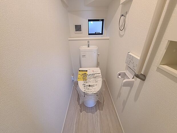 ウォシュレット機能付きのトイレ。換気のしやすい窓付きで、収納もあり実用性も兼ね備えた造り。 