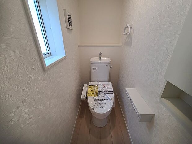 ウォシュレット機能付きのトイレ。換気のしやすい窓付きで、収納もあり実用性も兼ね備えた造り。