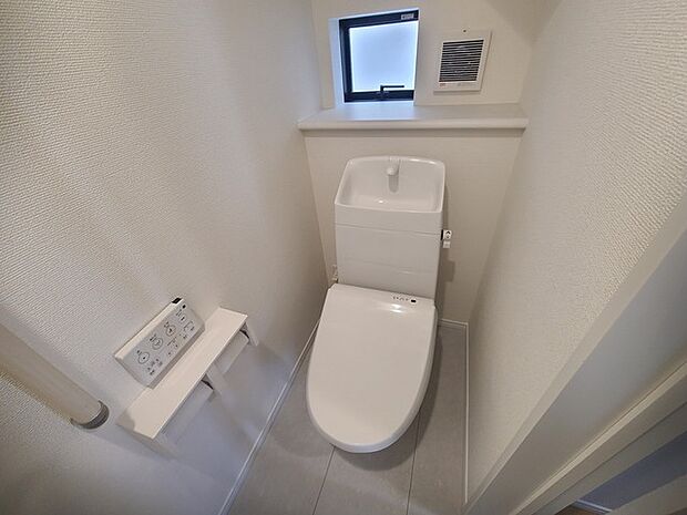 ウォシュレット機能付きのトイレ。換気のしやすい窓付きで、収納もあり実用性も兼ね備えた造り。