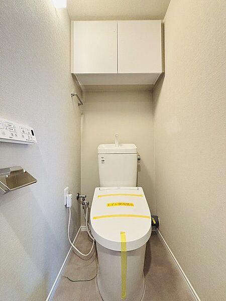 ウォシュレット機能付きのトイレ。収納もあり実用性も兼ね備えた造り。