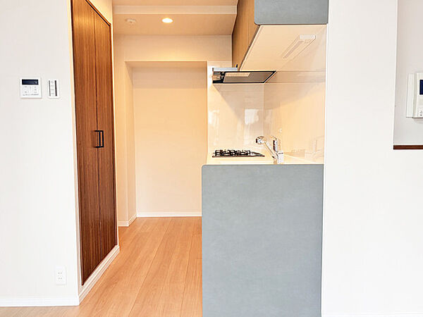 壁付のキッチンは上部に収納が作りやすいのがメリット。空間を有効活用したすっきりとしたデザイン。
