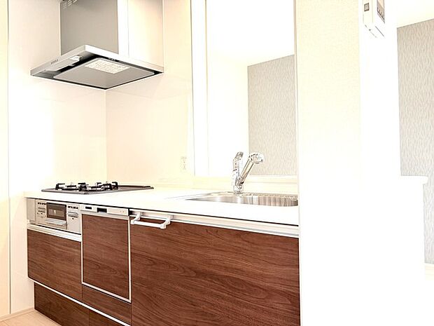 壁付のキッチンは上部に収納が作りやすいのがメリット。空間を有効活用したすっきりとしたデザイン。