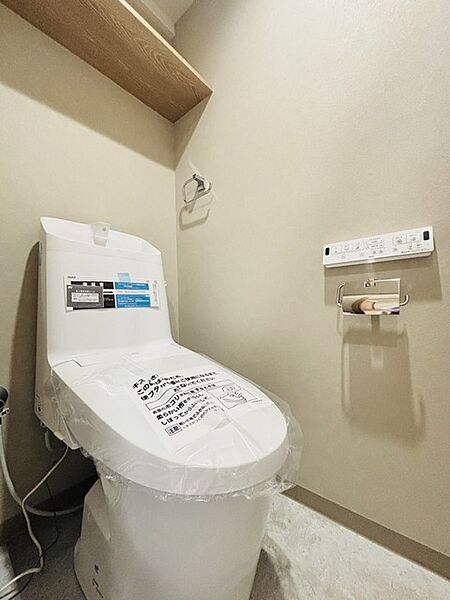 ウォシュレット機能付きのトイレ。収納もあり実用性も兼ね備えた造り。