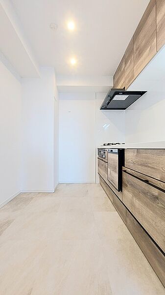 壁付のキッチンは上部に収納が作りやすいのがメリット。空間を有効活用したすっきりとしたデザイン。
