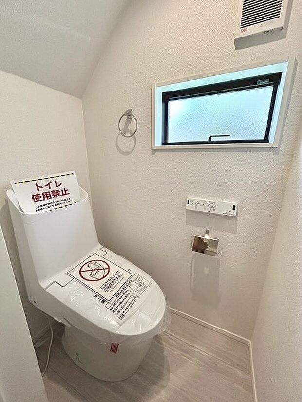 ウォシュレット機能付きのトイレ。換気のしやすい窓付きで、収納もあり実用性も兼ね備えた造り。