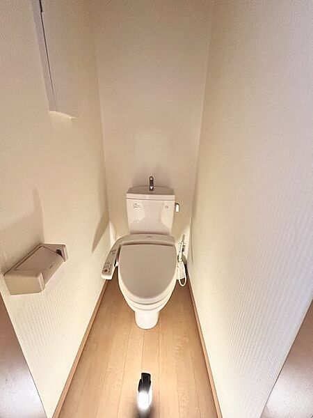 ウォシュレット機能付きのトイレ。収納もあり実用性も兼ね備えた造り。