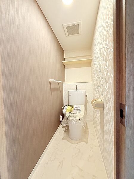 ウォシュレット機能付きのトイレ。収納もあり実用性も兼ね備えた造り。
