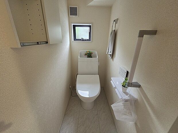 ウォシュレット機能付きのトイレ。換気のしやすい窓付きで、収納もあり実用性も兼ね備えた造り。 