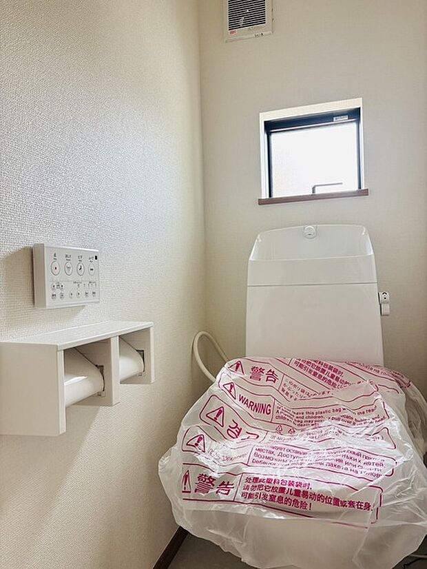 ウォシュレット機能付きのトイレ。換気のしやすい窓付きで、収納もあり実用性も兼ね備えた造り。